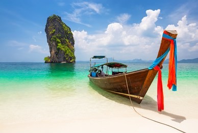 thai traditional wooden longtail boat and beautiful sand beach at koh poda island in krabi province. ao nang, thailand.