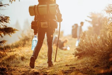 traveller with a group hiking in the mountains at sunset. 