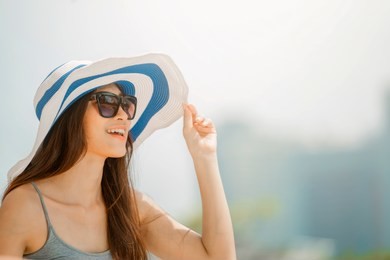 asian woman wearing fashion straw beach hat for skin care sun protection. face skincare beauty concept. beautiful adult girl portrait on summer vacation travel.