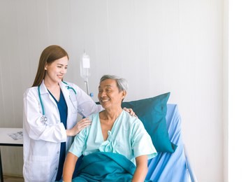 beautiful asian doctor taking care of senior patient in hospital bed