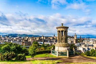 edinburgh, scotland: panoramic view of the city with the dugald stewart monument in the foreground viewed from calton hill.