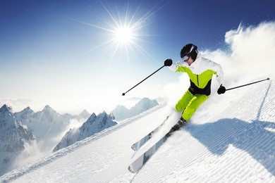 skier in mountains, prepared piste and sunny day