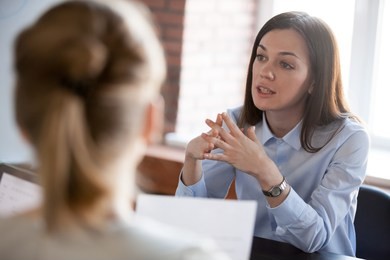 confident focused businesswoman, teacher or mentor coach speaking to business people at negotiations, woman leader speaker applicant talking at meeting or convincing hr during job interview concept