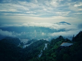 view of mountain,  fog and clouds. the sun rise with white clouds and green mountains cover by fog in genting highland, pahang.  mountains view landscape in vintage mode