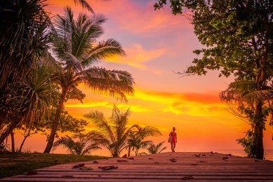 woman on the bach at sunset on karon beach phuket thailand