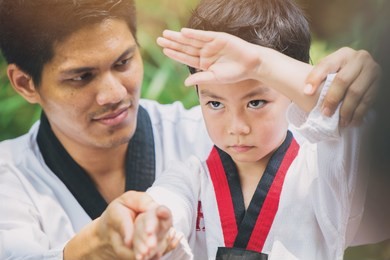 taekwondo master black belt teaching kid to fight guard