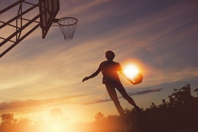 basketball player performs a slam dunk