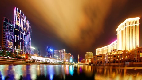 night scenery of the grand exterior of the venetian macao resort hotel and modern buildings by a pond in macau, china, with beautiful reflections of colorful neon lights in the water under twilight