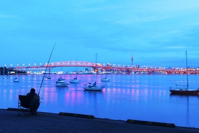 night view to the iconic harbour bridge auckland new zeland; light performance seeing from birkenhead wharf