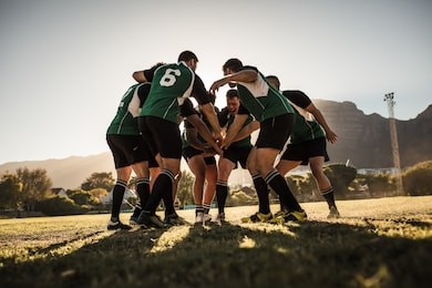 rugby team putting their hands together after victory. rugby players cheering and celebrating win.