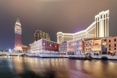 evening view of amazing buildings in venetian gothic style in cotai of macau. copies of palazzo ducale and bell tower of st mark. casinos and shopping malls of new gambling and tourism area.