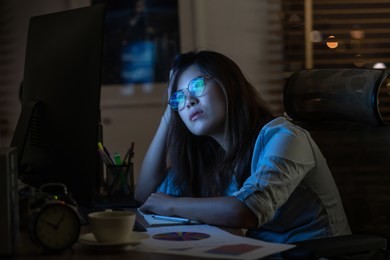 portrait of asian businesswoman working hard and looking the digital graphic on the table with front of computer desktop in workplace at late with serious action, work hard and too late concept