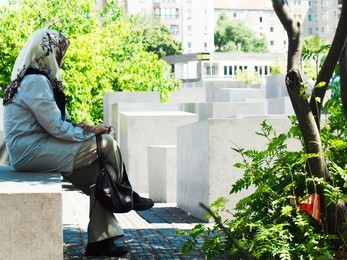 muslim woman resting at the memorial to the murdered jews of europe, in berlim, germany