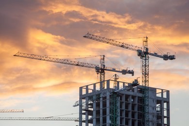 construction site with cranes against the background of the evening sky