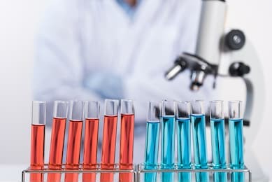 laboratory test tube in rack and microscope on scientist background, science research concept