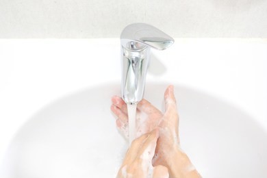 hand of beauty woman  wash your hands at the wash basin with foam, cleanse the skin and have water flowing through the hands. health and beauty concepts