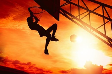 basketball player performs a slam dunk