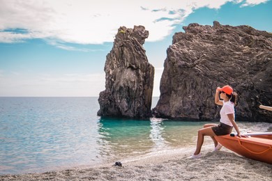 monterosso al mare pebble beach cinque terre, italy , young woman on vacation in italy cinque terre walking at the pebble beach with sand and stones