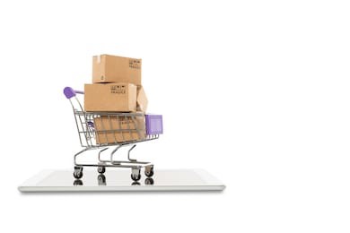 paper boxes in a trolley with tablet on white background,online shopping or ecommmerce concept