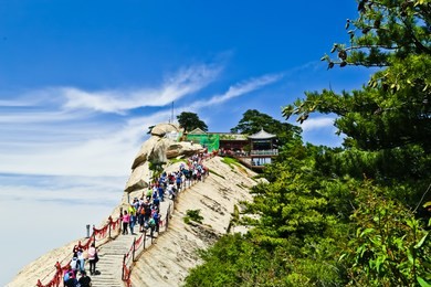 huayin, shaanxi/china - 5/27/2018: beautiful view of west peak and trail of huashan and hikers in huashan national park 