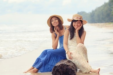 two asian younger woman relaxing on sea beach