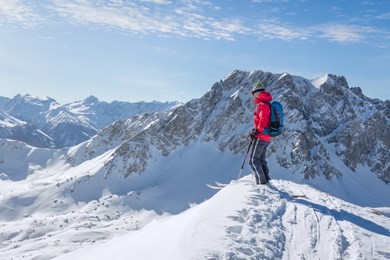 male ski tourer enjoying the view on a summit in the alps