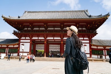 back view of an elegant traveler, she is carrying her backpack and walking into the todaiji temple