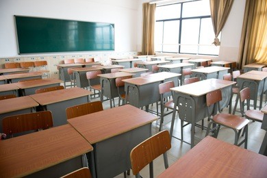 empty classroom with chairs, desks and chalkboard.