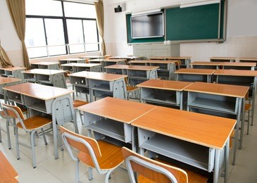 empty classroom with chairs, desks and chalkboard.