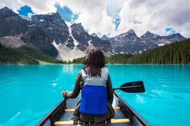 tourist canoeing on moraine lake in banff national park, canadian rockies, alberta, canada.
