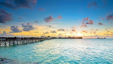long bridge heading to beautiful resort at mabul island during sunset