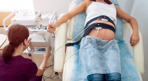 pregnant woman with electrocardiograph check up for her baby. fetal heart monitoring. diagnostic, healthcare, medical service