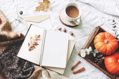 autumn breakfast in bed composition. card, notebook mockup. cup of coffee, eucalyptus leaves, pumpkins on wooden tray. white linen background. thanksgiving, halloween concept. flat  lay, top view.