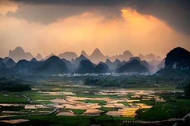 sunset with reflection from rice paddy in yangshuo china