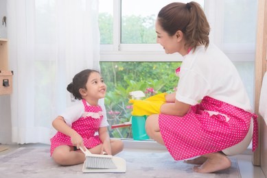 asian mother teaching daughter cleaning their home . family housework concept.