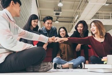 young successful businesspeople are fist bumping after working hard at new project