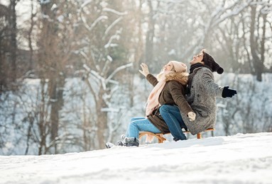 two young people sliding on a sled 