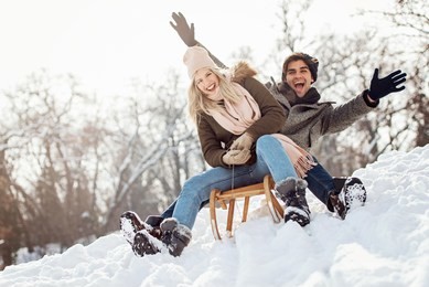 two young people sliding on a sled 