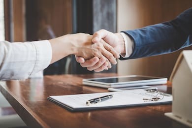 real estate agent and customers shaking hands together celebrating finished contract after about home insurance and investment loan, handshake and successful deal.