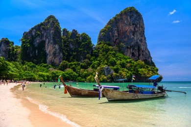 long tail boats and rocks on railay beach west, ao nang, krabi, thailand