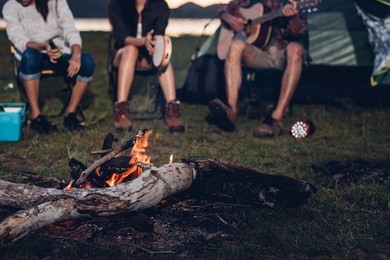 camping tent camp in nature happy friends group night party bonfire and playing guitar together in summer at nature forest