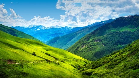 alpine mountain landscape. svaneti mountains ranges. green grassy hills in georgian highlands on sunny bright day. amazing view on scenery wonderful vibrant nature. beautiful day in caucasus valley