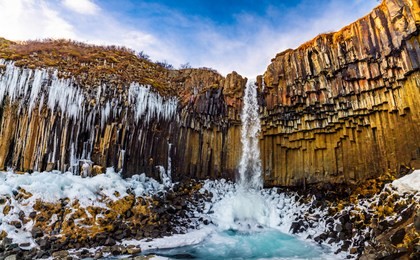 a big waterfall called svartifoss or black fall in skaftafell national park in iceland. it is a great black basalt wall behind the falls is its signature. one of icelandic symbol and landmark