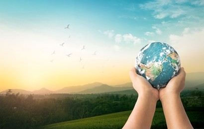 world environment day concept: human hands holding earth global over mountain sunrise background. elements of this image furnished by nasa