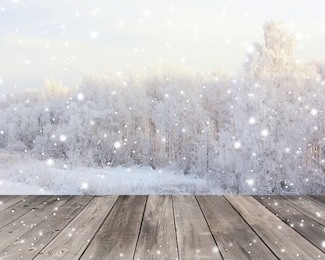 empty wood flooring on blurred winter background. empty space for your object. backdrop, table layout with winter landscape and snowflakes.                               
