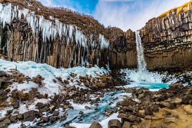 a big waterfall called svartifoss or black fall in skaftafell national park in iceland. it is a great black basalt wall behind the falls is its signature. one of icelandic symbol and landmar