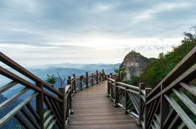 the wooden walkway on the top of the mountain, in the distance is the skyline and the rolling mountains, in zhangjiajie, hunan province, china.