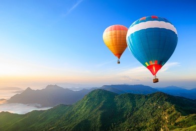 colorful hot-air balloons flying over the mountain