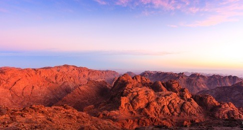 barren desert mountains illuminated by the rising sun from the top of mount sinai