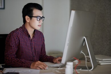 asian it engineer working with database on computer in his office